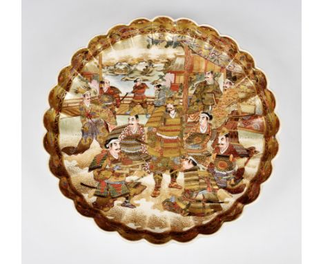 A large Japanese Satsuma scalloped edge charger / dish, probably Meiji period (1868-1912), signed with brown and gold oval se