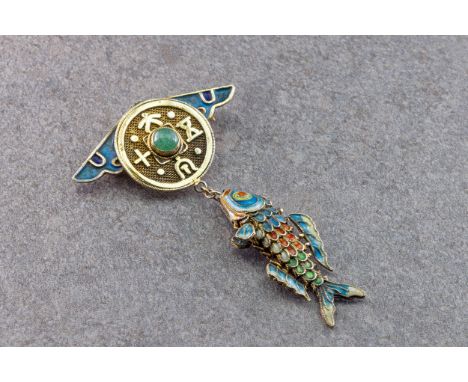 A Chinese silver gilt and enamel brooch, first half 20th century, with an articulated fish suspended from a winged, coin styl