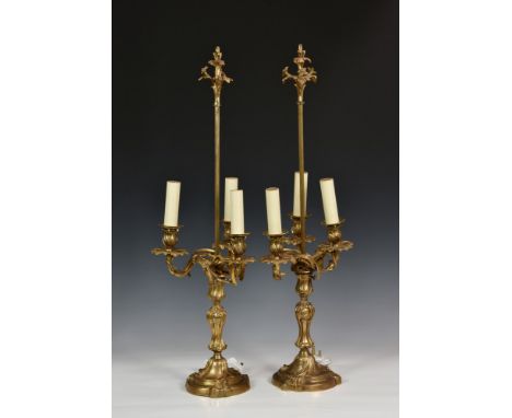A pair of Louis XV style gilt bronze three light candelabra lamps, second half 20th century, with foliate and incised floral 