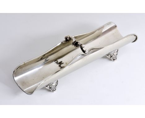 A Continental silver asparagus dish, stamped 800, of elongated wavy form with scroll handle, raised on four pierced fleur de 
