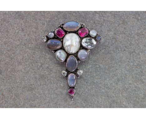 An Arts &amp; Crafts brooch in the manner of Sybil Dunlop, early 20th century, set in silver with beaded borders, with cushio