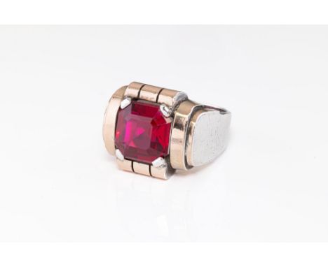 A silver and synthetic gemstone signet ring, the step-cut red gemstone, possibly synthetic ruby, within a gold plated, geomet