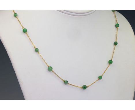 A mid-century 9ct gold and jade necklace, the belcher chain interspersed with small green jade beads, 21in. (53.25cm.) long..