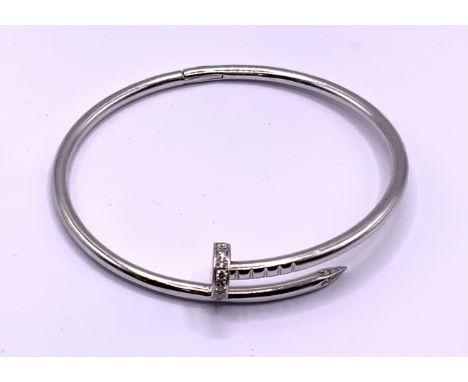 A heavy white gold custom design hinged bangle in the form of a nail set with diamonds , (Minimum 9ct gold) approximately 40g