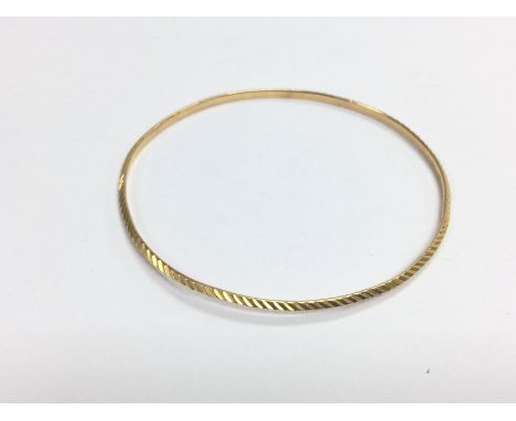 A fine gold diamond cut 2mm slave bangle, approx 8.8g (A14). Shipping category A.