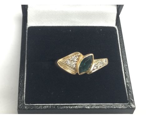 A 14ct gold ring set with small diamonds and a central green stone, approx 2.5g and approx size R. Shipping category A.