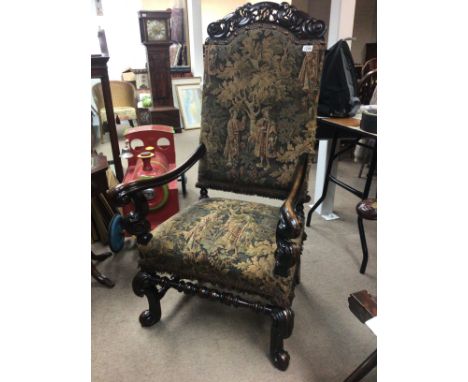 A Charles II style chair with a carved top rail above pictorial tapestry upholstery with scroll arms and legs. good condition