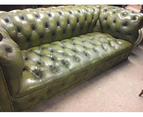 A green leather chesterfield sofa with button back and seat 198 cm x 90 cm .