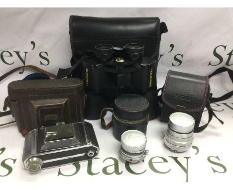 A Zeiss Ikon camera, two Leica lenses and a pair of Bushnell binoculars. Shipping category D.