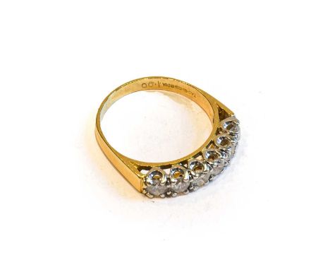 An 18 carat gold diamond six stone ring, the round brilliant cut diamonds in white claw settings, to a yellow tapered shoulde