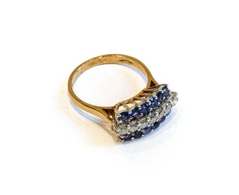 A 9 carat gold sapphire and diamond ring, a row of round brilliant cut diamonds flanked by rows of round cut sapphires, in wh