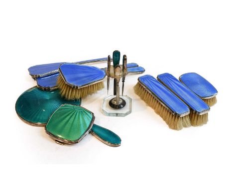 A collection of assorted silver and enamel dressing-table items, enamelled in blue or green over various engine-turned ground