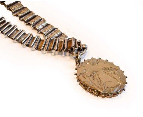 A Victorian silver locket on chain, an oval locket with foliate and bird engraved decoration, on a rectangular link foliate e