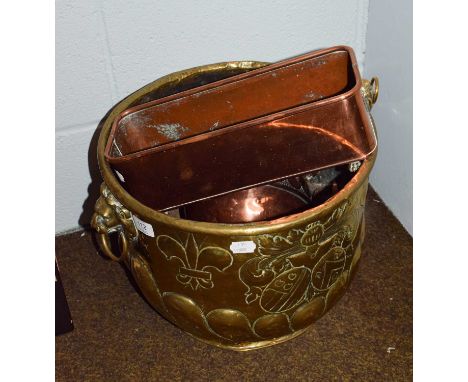 A Victorian embossed brass coal bucket with twin lion mask handles, decorated with a crest and fleur-de-lis motifs, 29cm wide