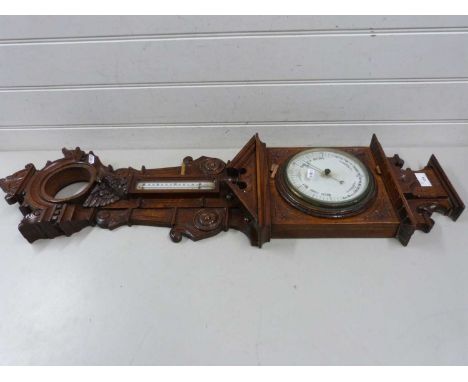 A large and elaborate late 19th Century barometer and thermometer set in a heavily carved case (a/f)