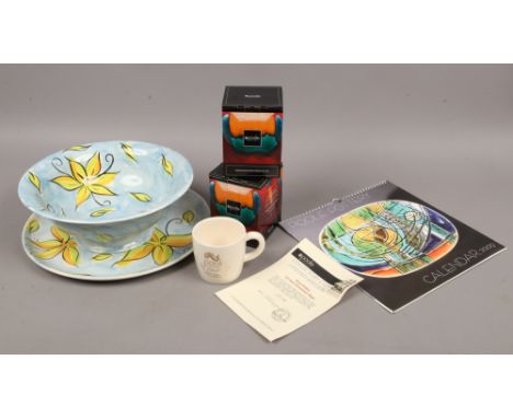 A collection of Poole pottery to include bowl and charger, both signed, two collectors club boxed mugs and the Poole pottery 