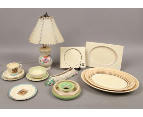 A group lot of Clarice Cliff pottery to include table lamp, commemorative cup and saucer, meat plates, dishes etc.