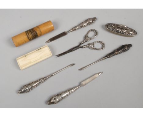 A Mauchline ware bodkin, toothpick case and a quantity of silver handled manicure tools.