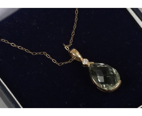 A cased 9ct gold green amethyst and diamond pendant on trace chain.