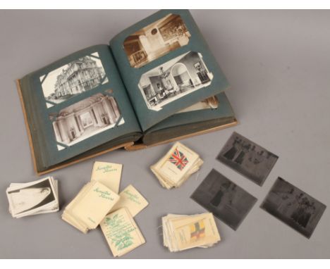 An album of vintage postcards and a quantity of cigarette cards and silks.