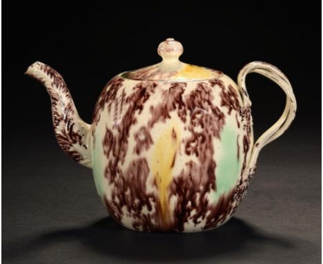 A STAFFORDSHIRE OR YORKSHIRE TORTOISESHELL GLAZED CREAMWARE OVOID TEAPOT AND COVER, C1765  with Leeds type entwined handle, c