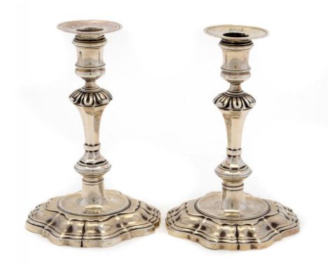 TWO GEORGE II SILVER CANDLESTICKS  crested and a pair of later nozzles crested to match, 17.5cm h, marked under the foot with
