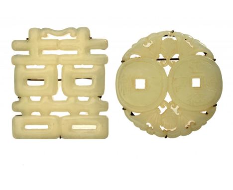 TWO CHINESE CELADON JADE PLAQUES CARVED AS A SHOU CHARACTER  OR CASH, 20TH C   in silver brooch mount, 5.3cm diam or 5.5cm h 