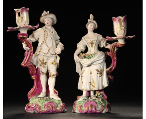 A PAIR OF DERBY SHEPHERD AND SHEPHERDESS CANDLESTICK FIGURES, C1775 decorated predominately in puce and green, 25.5 and 27cm 