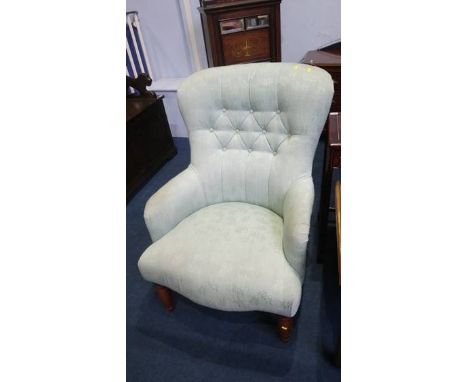 A light green button back armchair