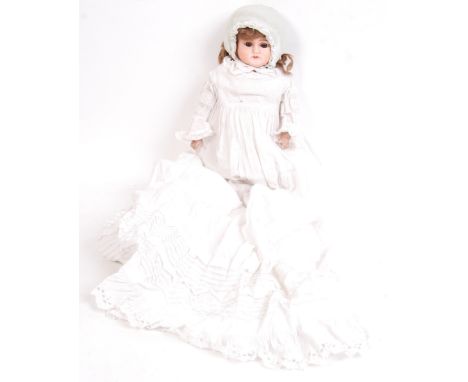 An antique likely late 19th / early 20th century composition headed child's doll. Likely German, with original lace gown and 