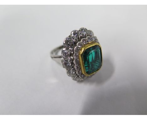 An impressive diamond ring, with a central emerald colour glass measuring  approx 11mm x 9mm x 6mm - surrounded by three rows