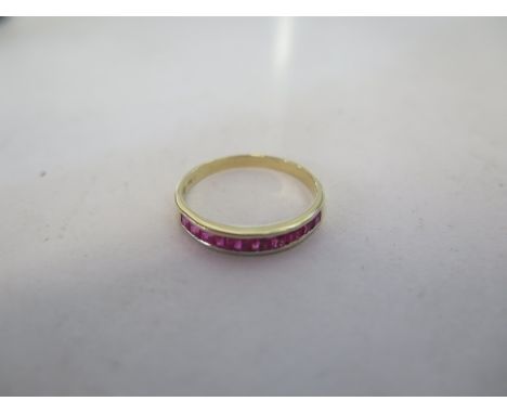 An 18ct yellow gold band ring set with nine rubies, size P/Q approx 2 grams, in good condition 