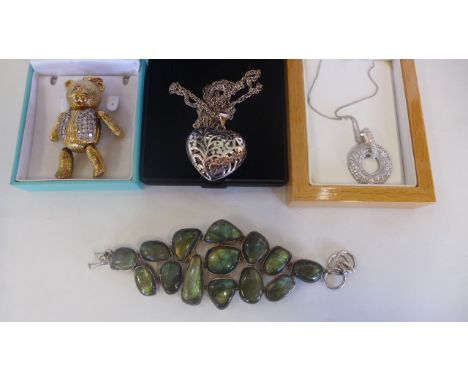 A silver heart pendant on chain, a silver bracelet and a silver gilt articulated bear pendant and a silver hoop pendant on ch