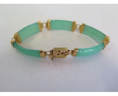A jade and yellow metal bracelet, approx 20cm long, in good condition 