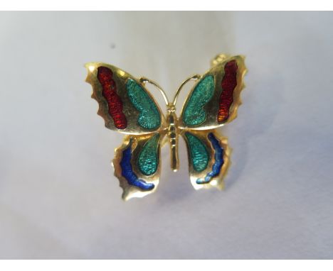 A yellow metal and enamel butterfly brooch, with indistinct markings, approx 2.2cm long, approx 4.3 grams, in good condition 