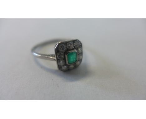 A platinum diamond ring with central stone, believed to be an emerald, ring size Q, approx 3.8 grams, some usage and abrasion