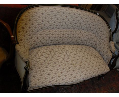 A late 19th Century French ebonised and brass strung framed two seat salon sofa on cabriole front legs to castors