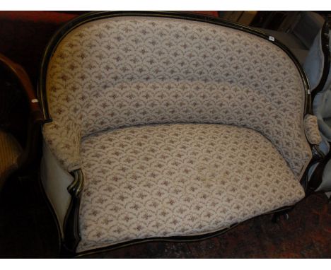 A late 19th Century French ebonised and brass strung framed two seat salon sofa on cabriole front legs to castors