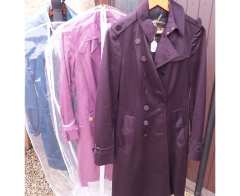 A Burberry purple trench coat, a similar teal trench and a Celine purple trench coat