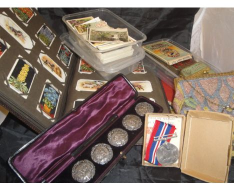 A box containing assorted cigarette cards, a cased set of five white metal buttons, each depicting a shepherd playing a music