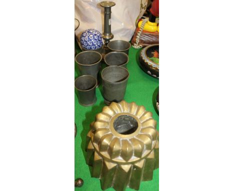 A Victorian brass circular jelly mould, six 19th Century and later pewter beakers, ejector candlestick and a blue-glazed pott