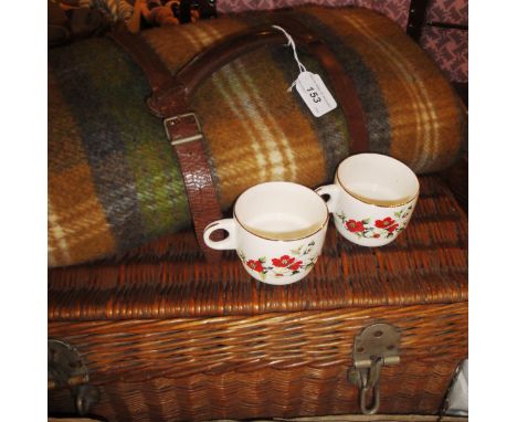 A wicker picnic hamper with fitted contents to include Brexton's teacups, etc, and a picnic blanket in leather straps
