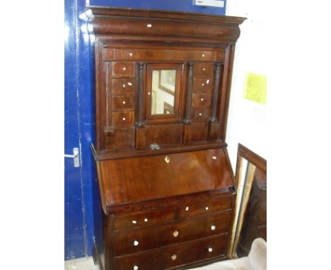 A 19th century continental mahogany bureau cabinet, the top with cushioned pediment above a arrangement of drawers to include