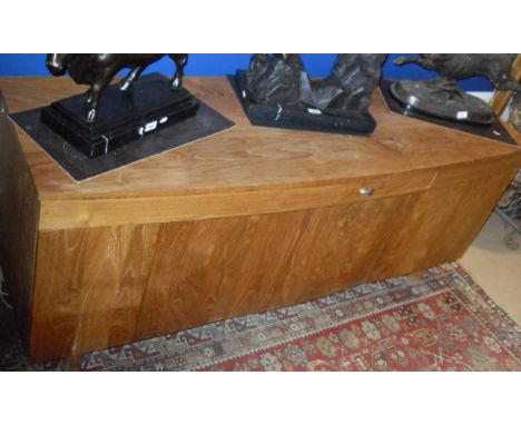 A modern teak shallow bow fronted sideboard, the plain top above a single drawer and three pairs of cupboard doors on turned 