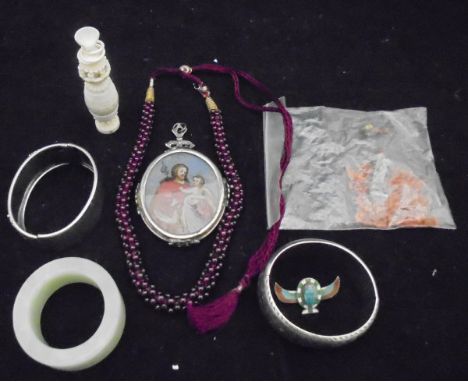 A box of assorted jewellery to include two white metal bangles, a reverse painted pendant depicting a mother and child to one