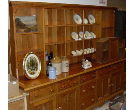 A large pitch pine dresser, the boarded three tier plate rack with various shelving and drawers on a base of three drawers fl