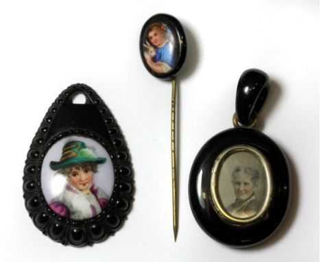 Two carved jet and miniature portrait pendants and a jet and miniature portrait stick pin.