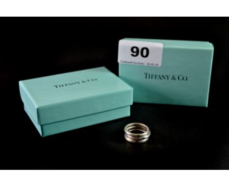 Three Tiffany & Co silver rings set with an emerald, sapphire and a ruby.