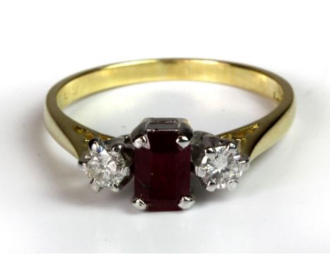 An 18ct gold ring set with an emerald cut blood pigeon ruby (0.65ct) and two diamonds (0.25ct), (N).