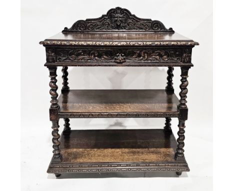 Late 19th/early 20th century oak three-tier buffet, the shaped back stand carved with a green man mask, the top with carved f